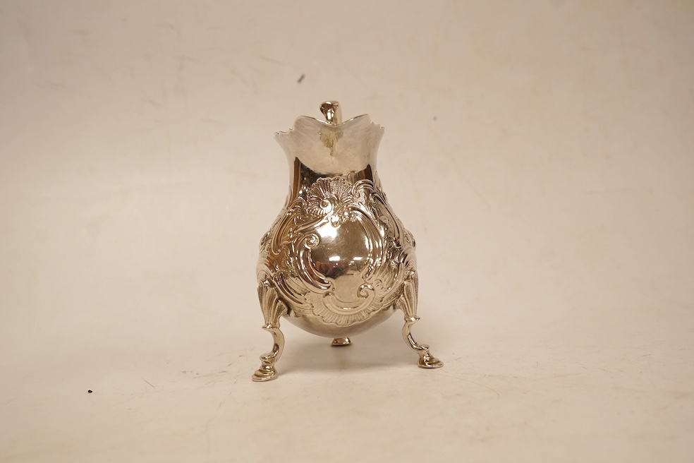 A late George II silver baluster cream jug, with later embossed decoration, on three hoof feet, Samuel Meriton I London, 1756, 10.6cm, 3.3oz.